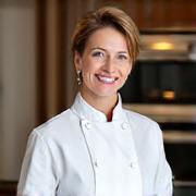 Portrait of Head Baker Elara Vance, smiling confidently in a chef's jacket.